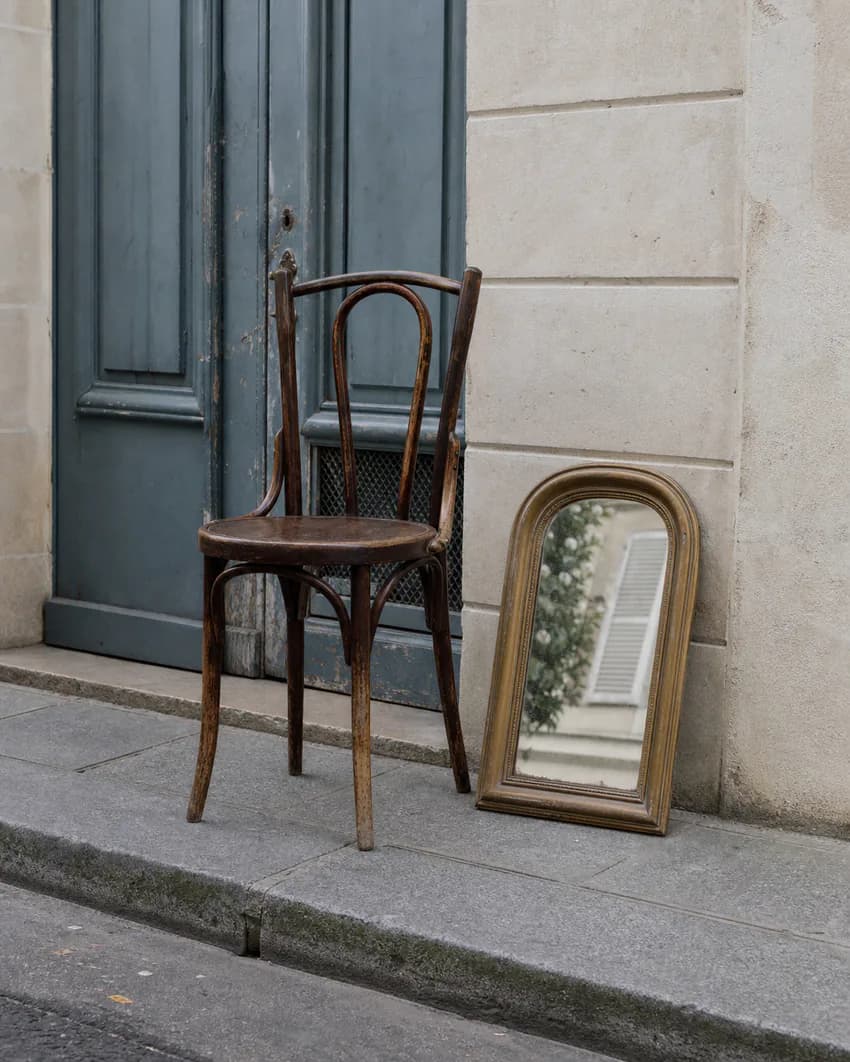 Chaise et miroir laissés devant un immeuble parisien