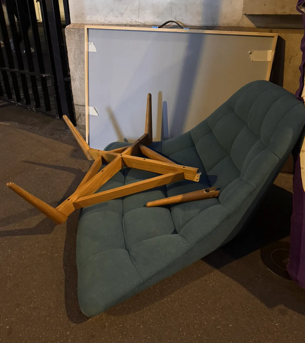 Fauteuil vert et table basse démontée abandonnés dans une rue de Paris